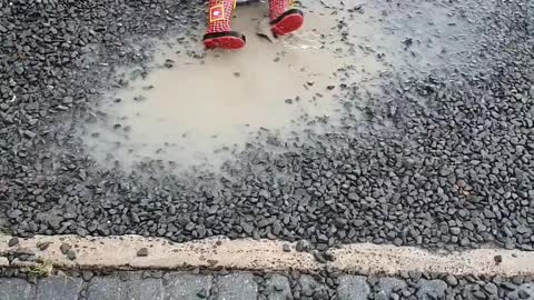 Baby Playing in the Rain and Muddy Puddle