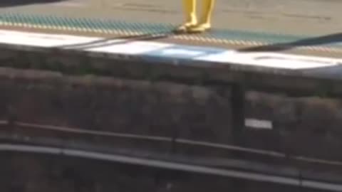 A woman in yellow body suit standing on subway platform