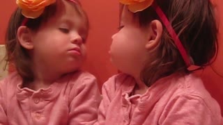 Girl distracted by own reflection while singing ABCs