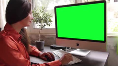 Woman Using Computer With Green Screen Display. Free stock footage