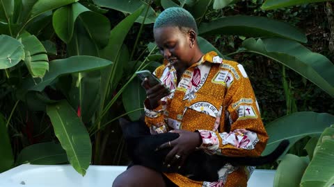 Beautiful Queer medium shot of a girl playing with a cat