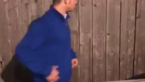 Guy blue sweater jacket pulls on wooden fence breaks hits car