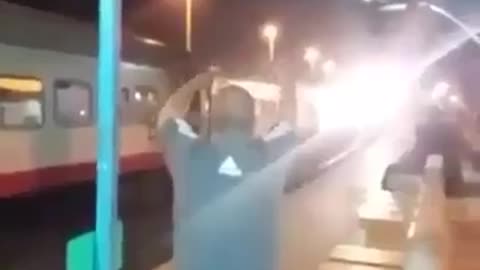 The man dances to the sound of the train
