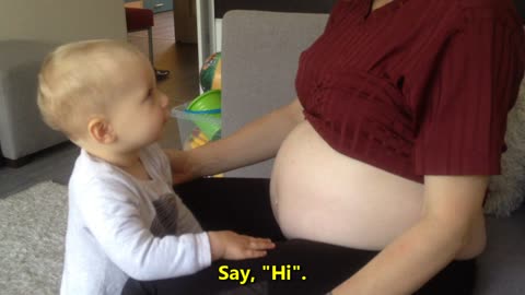 Baby kisses and hugs pregnant mother's belly