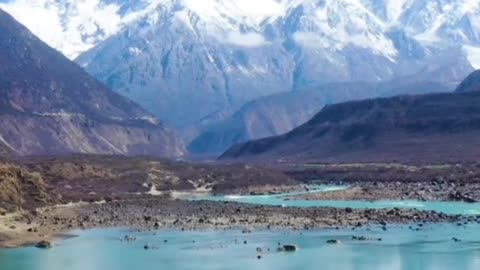 The blue lake beneath the snow-capped mountains