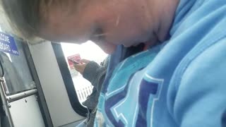 Woman with blue sweater asleep on train