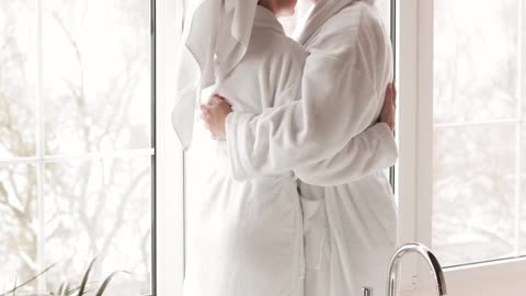 A couple wearing Bathrobes Kissing and Hugging