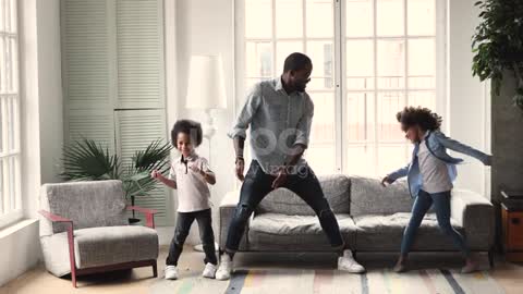 African dad dancing having fun with kids in living room stock video