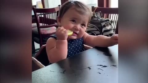 girl baby eating lemon