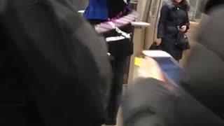 Girl plays the violin and hula hoops in subway station