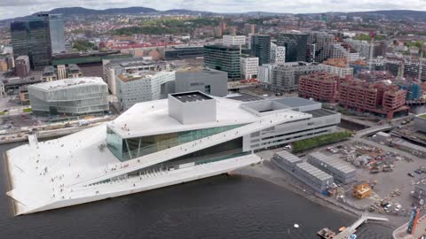 aerial view on the national oslo opera house and oslo downtown against cloudy sky