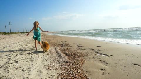 Girl running in the beach with her dog