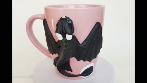 Whitebeard "How to Train Your Dragon" on a pink cup. Son of Toothless made of polymer clay on a mug.