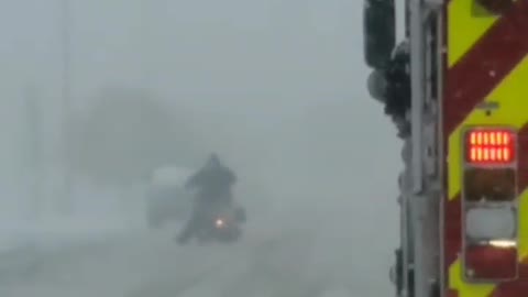 Firetruck Escorts Motorcycle Through the Snow