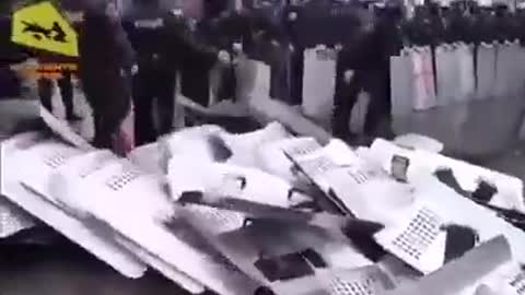 Police line throwing down their riot shields - UKRAINE?