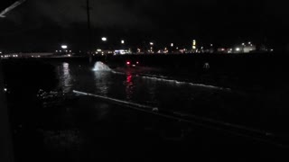 Traffic drives through flooded street in California