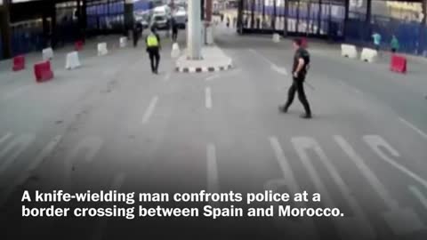 Spanish police throw traffic barrier at knife-wielding man