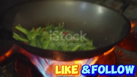 Slow Motion close up Chef Cooking frying vegetable in Wok Pan with Ingredients and Fire Flames