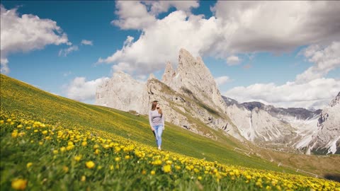 young woman hiker walking on a beautiful hill and enjoying view of seceda mountain dolomites italy