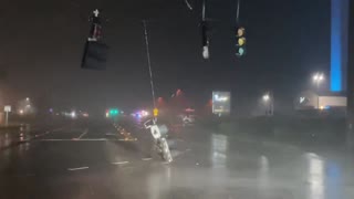 Stop lights dangle from extreme Hurricane Nicole damage
