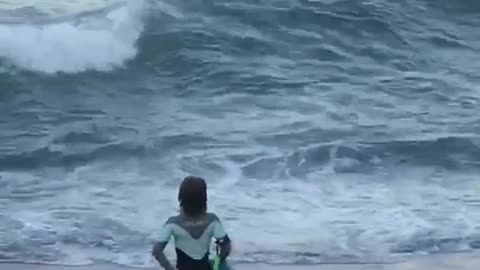 Girl black wet suit dancing on beach sand watching waves