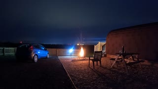 Campfire next to a glamping pod. Nightlapse