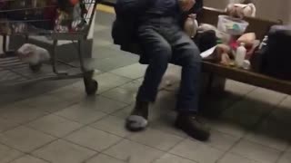 Guy sitting next to grocery store cart on subway