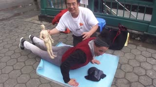 Luodong Massages Skinny Woman's Back On Sidewalk