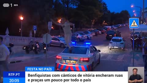 Adepto festeja vitoria do Benfica em cima de um carro da policia