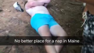 Drunk guy teal shorts asleep on dirt