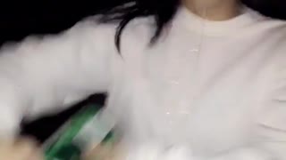 Girl in white shirt opening drink can with mouth