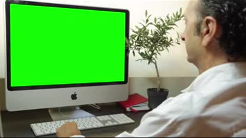 Man is working on a computer with mock-up green screen, makes call. Free stock f