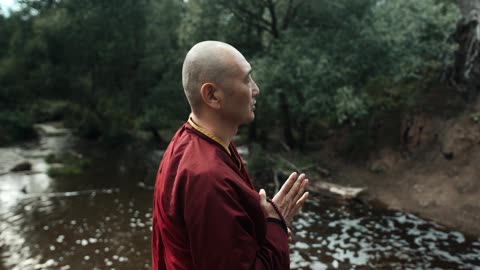 A Buddhist Monk Praying Outdoors