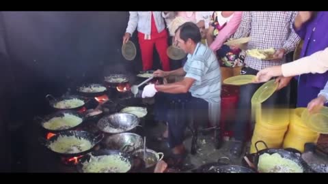 Chef manages multiple pans at once as he whips up pancakes for locals in Vietnam.