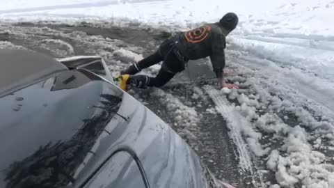 Guy skiing gets pulled by car, does the splits and falls down