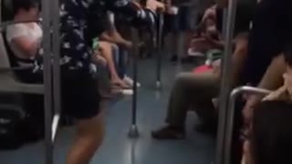 Guy blue button up shirt white shoes dancing on subway train