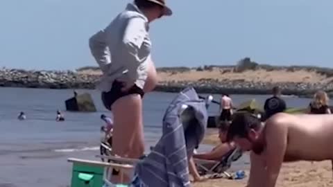 THIS MAN DIGS SAND TO FIT ON HIS LOVELY WIFE'S PREGGY BELLY