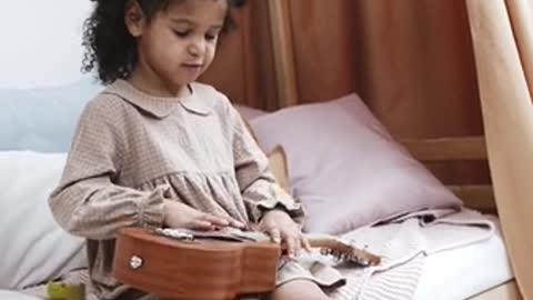 A Girl Learning To Play A Ukelele