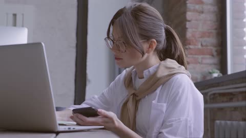 busy woman working with her laptop and smartphone