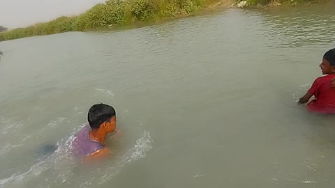 Little boy swimming in river