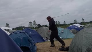 Guy hits blue tent with golf club