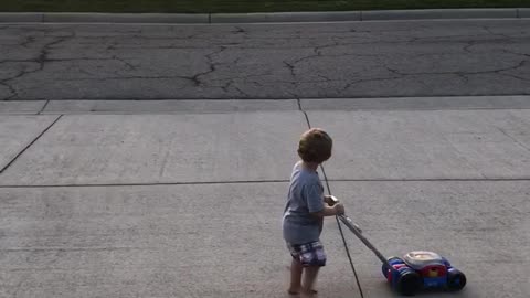 Little Boy Imitates Older Neighbor As He Mows His Lawn