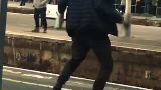 Man dancing on edge of train ledge