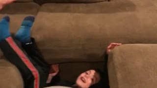 Kid jumps off couch onto exercise ball and falls down