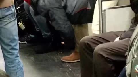 Guy in khaki pants and timbs stretching in subway