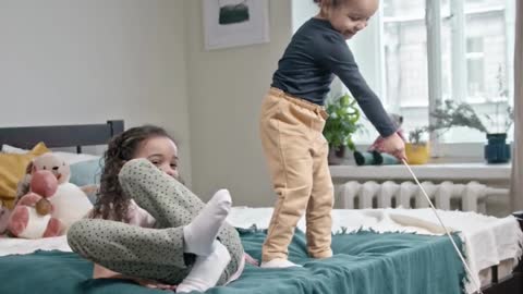 Two baby play with their kitty