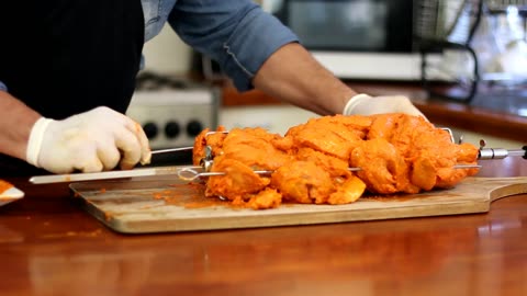 Tandoori chicken on charcoal rotisserie grill