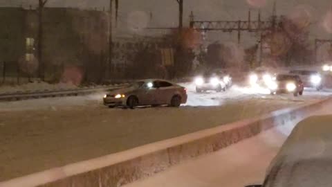 Car Does Donuts on Highway During Snowstorm