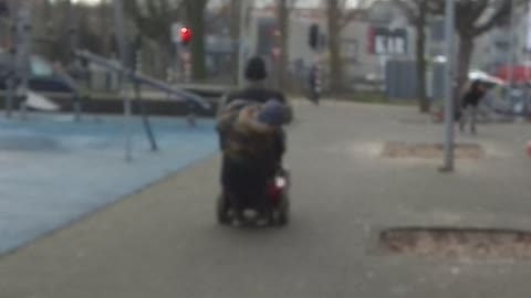 Old man makes wheelies on a scootmobiel Old man makes wheelies on a scootmobiel