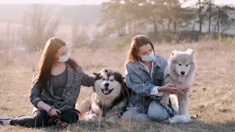 Women With Face Masks Petting Dogs